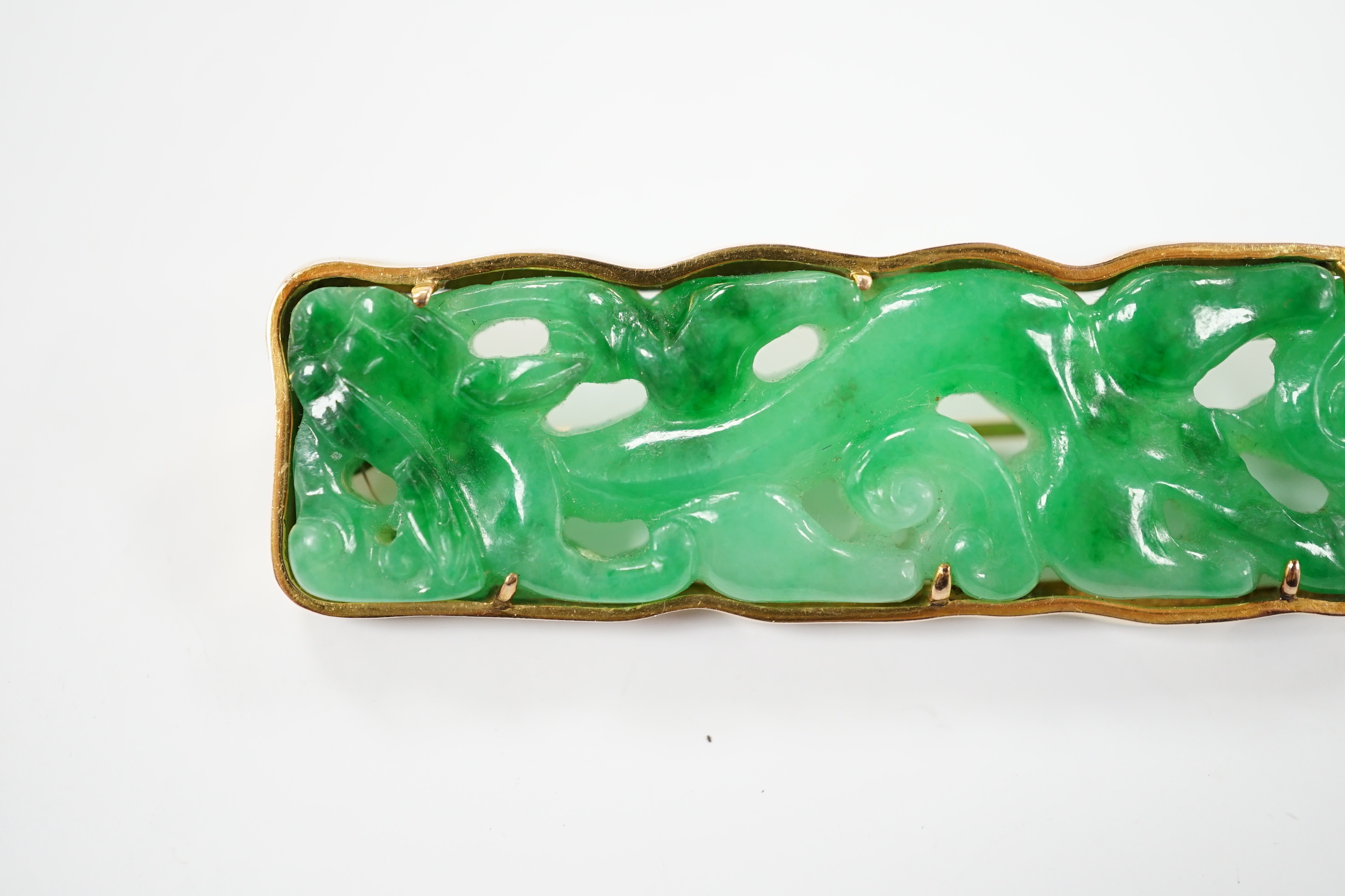 A Chinese 14k yellow metal and carved jade set rounded rectangular brooch, 63mm